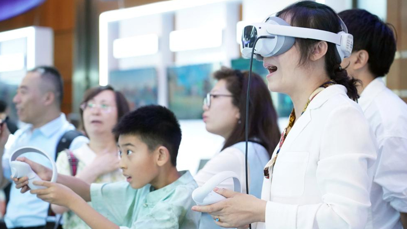 观众在2024全球数字经济大会数字经济沉浸式体验区体验一款VR设备