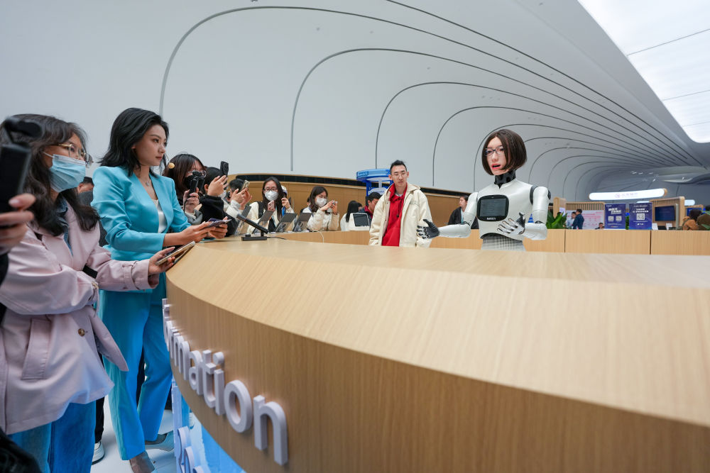 在中关村国际创新中心咨询台，“迎宾”机器人小诺（右一）向观众介绍自己